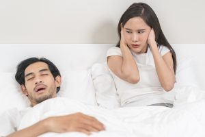 couple struggles to sleep due to snoring and sleep apnea